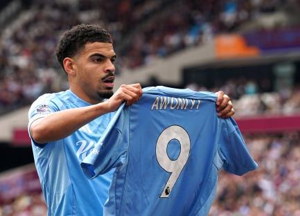 Nottingham Forest players celebrating a goal while holding up a jersey with