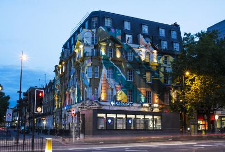 Megaro Hotel building at night with colorful artwork.