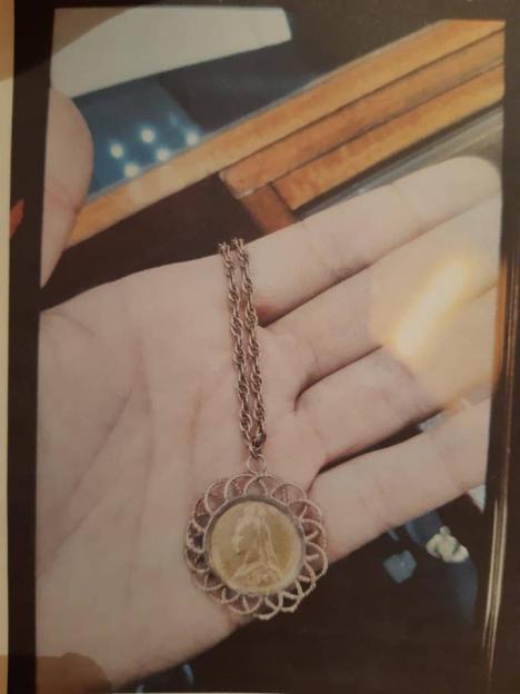 Stolen gold coin pendant on a rope chain.