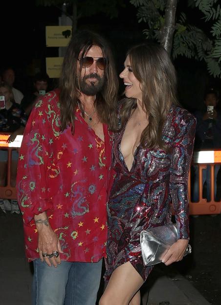 Billy Ray Cyrus and Elizabeth Hurley at an event.