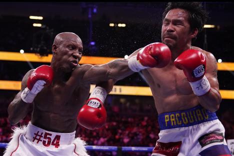 Yordenis Ugas punches Manny Pacquiao in a boxing match.