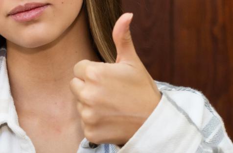Woman giving thumbs up and thumbs down.