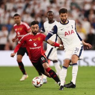 Bruno Fernandes of Manchester United and Rodrigo Bentancur of Tottenham Hotspur competing for the ball during a soccer match.