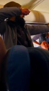 Man attempting to open airplane emergency exit door.