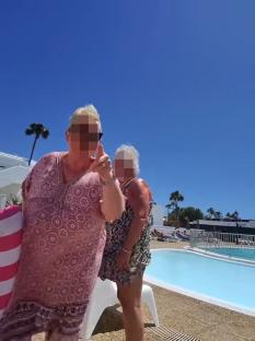 Screenshot of a woman arguing with another woman by a pool.