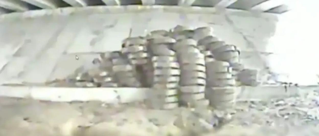 Screenshot of tire stacks under a bridge.