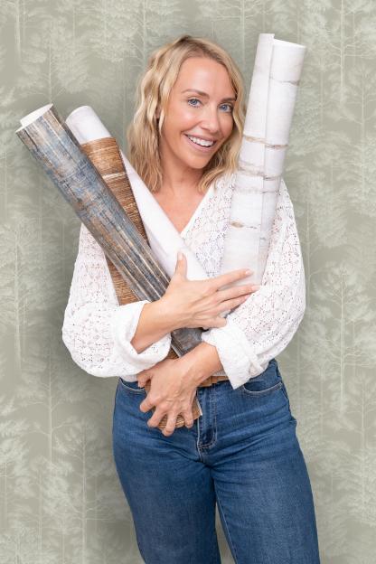 Laura Hamilton holding rolls of wallpaper for the I Love Wallpaper campaign.
