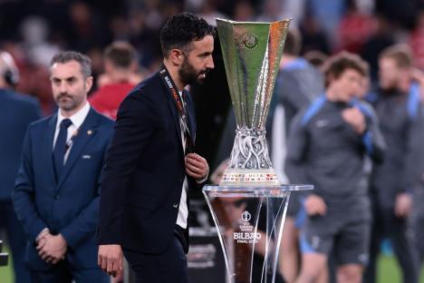 Ruben Amorim, Manchester United FC Head Coach, walks past the UEFA Europa League trophy after receiving his runner's-up medal.