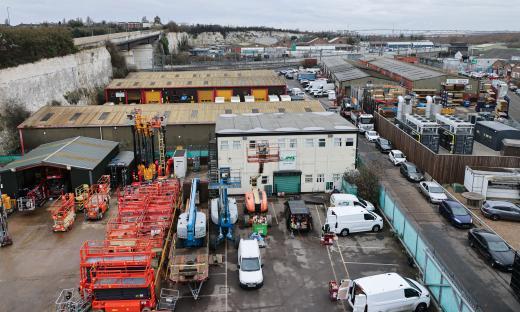 Aerial view of an industrial area with numerous buildings and parked vehicles.
