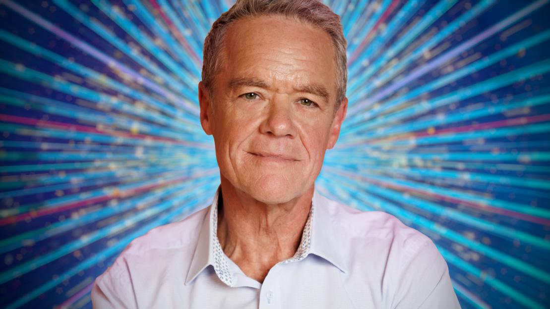 Portrait of a man in a light-colored shirt against a sparkly background.