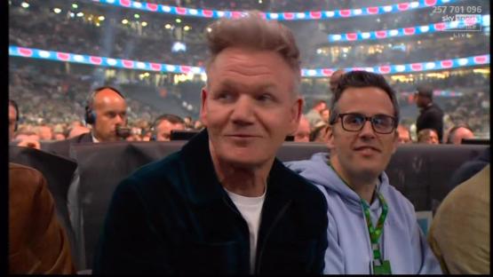 Gordon Ramsay and another man sitting in a stadium.