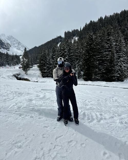 Couple in ski gear standing in the snow.