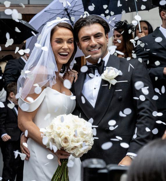 Vicky Pattison and Ercan Ramadan smile at their wedding at Marylebone Old Town Hall as confetti falls around them.