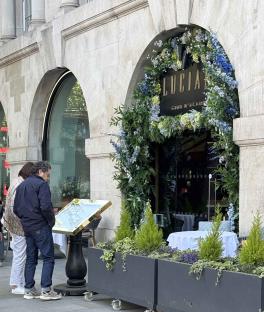Exterior of Lucia by Gino D'Acampo restaurant in London, with two people looking at a menu.