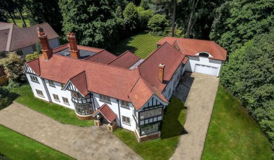 Aerial view of a large house with red tile roof and attached garage.
