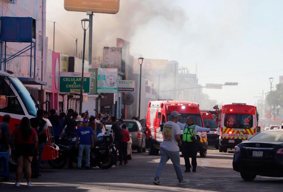 People gather near the site of a fire-damaged chain department store in Hermosillo, Sonora state, northern Mexico, on Nov. 1, 2025.