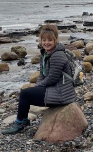 Woman sitting on a rock at the beach.