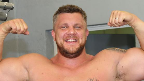 Luke Stoltman flexing his biceps.