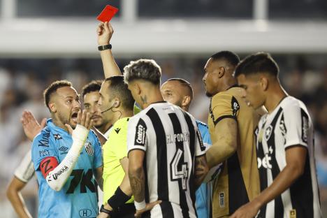 Neymar of Santos receives a red card during a soccer match.