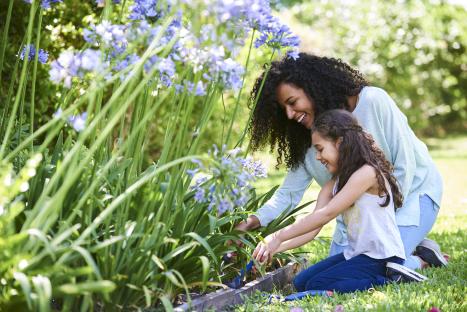 Smiling mother and daughter gardening together.