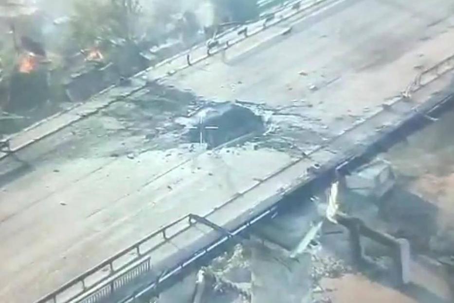 Bombed bridge in Kherson with damaged gas pipeline.