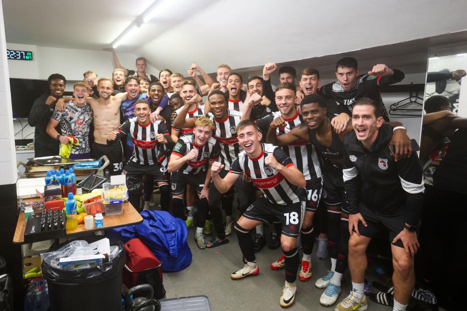 Grimsby Town soccer players celebrating in the locker room.