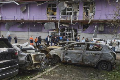 Municipal workers cleaning up burnt cars in Kyiv, Ukraine.