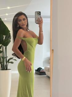 Woman in a lime green dress taking a selfie.
