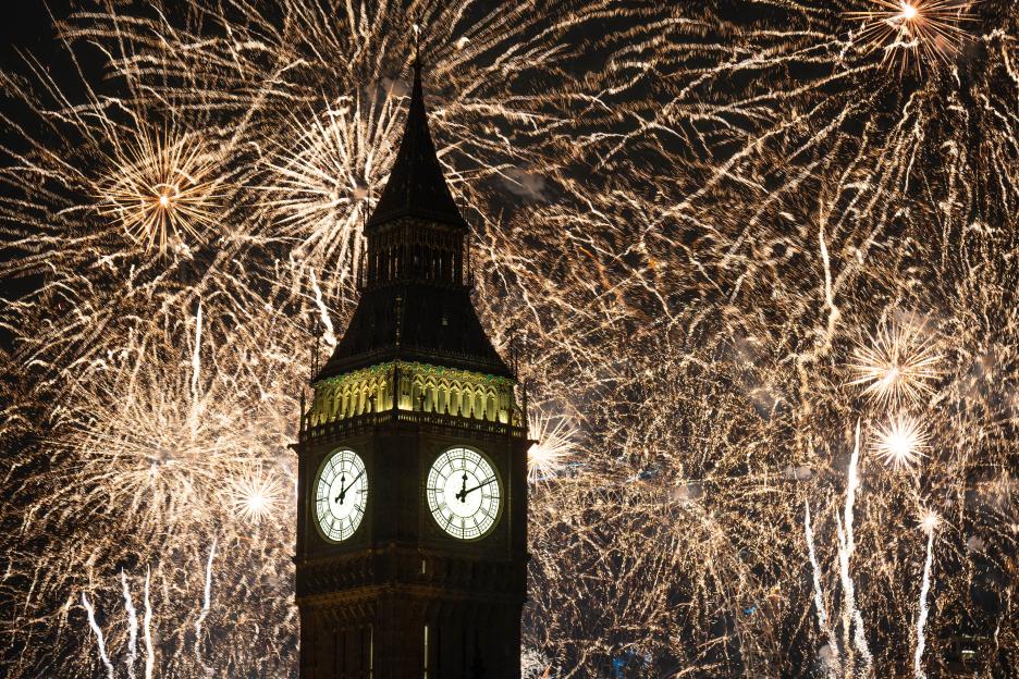Fireworks in the sky over the Elizabeth Tower, also known as Big Ben, and the London Eye.