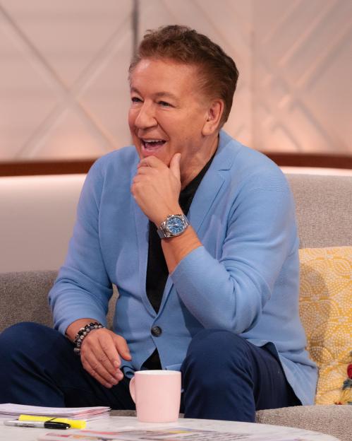 Ross King sitting on a couch on the set of the "Lorraine" TV show.