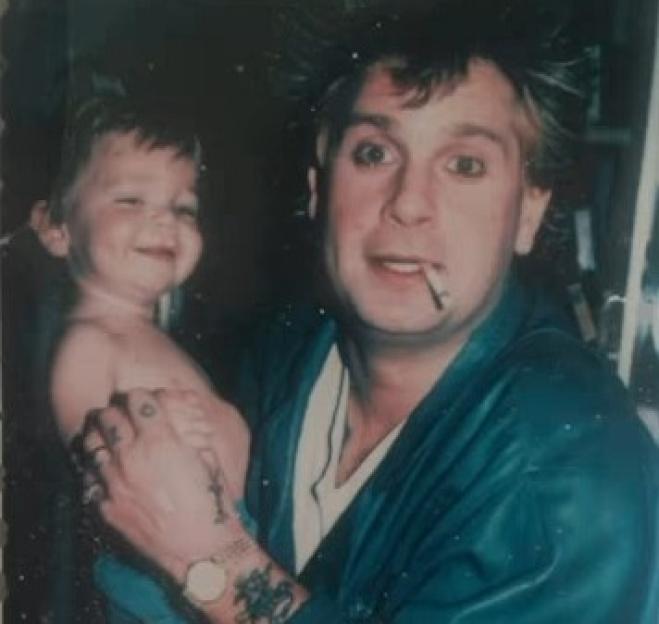 Photo of a young Jack Osbourne being held by Ozzy Osbourne.