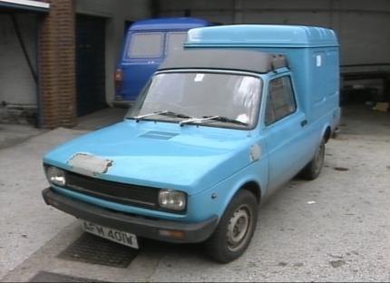 Light blue Fiat van parked in a garage.