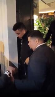 Ronaldo leaving a restaurant, assisted by someone.
