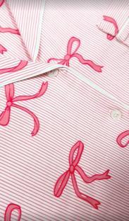 Close-up of pink striped pajamas with pink bows.