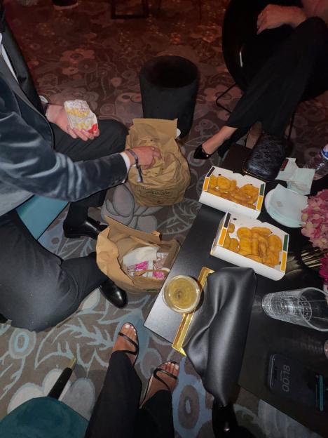 People sharing fast food and drinks in an indoor setting.