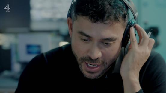 A man wearing headphones speaks intensely into a microphone.