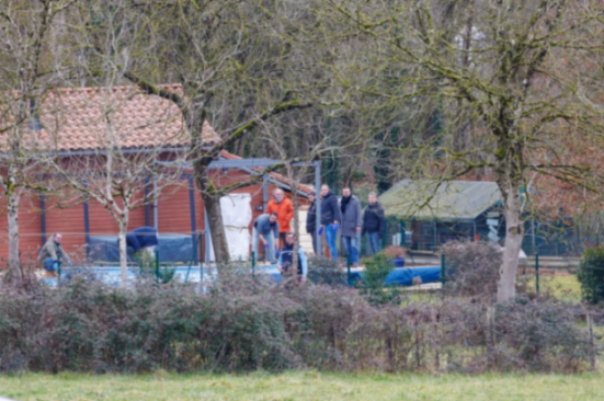 People gathered near a pool and buildings.