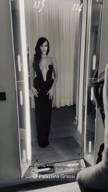 Eva Murati in a black dress, looking in a mirror.