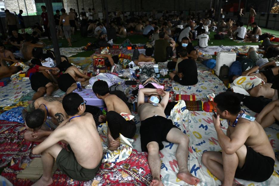 Alleged scam center workers and victims resting at the Thailand border checkpoint in Myanmar.