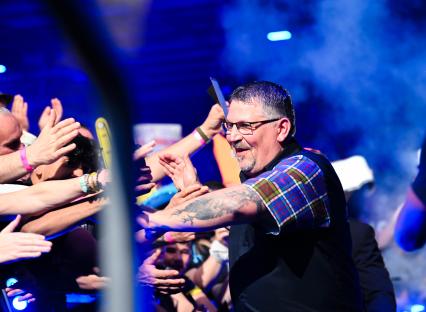 Gary Anderson interacting with fans at a darts event.