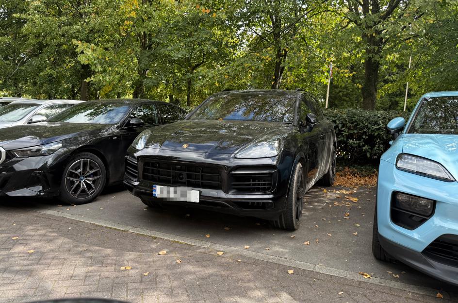 Black Porsche Cayenne parked in a parking lot.