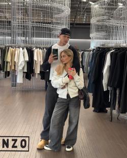 Couple taking a selfie in a clothing store.