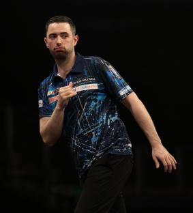 Luke Humphries of England celebrates during a darts match.