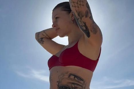 Model nepo baby strips to a bikini and shows off her tattoos – but can you guess who her very famous rock star dad is?