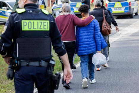 German police escorting migrants near the Poland border.