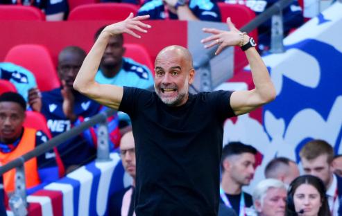 Pep Guardiola celebrating at a soccer match.