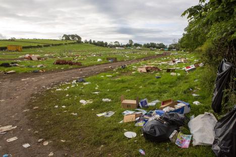 Litter and trash scattered across a grassy field.
