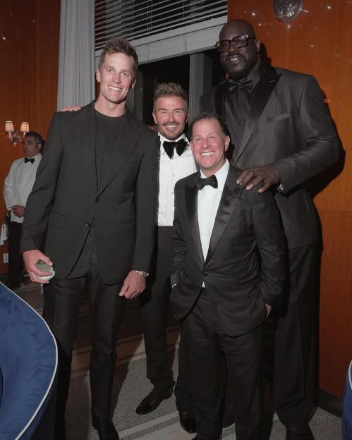 Four men in suits at a celebratory event.