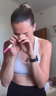 Woman crying while holding a pregnancy test.
