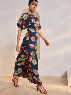 Woman in a floral maxi dress and red heels.